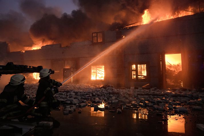 Slökkviliðsmenn berjast hér við mikinn eld í vöruskemmu í útjaðri Kænugarðs, eftir sprengjuárás Rússa.