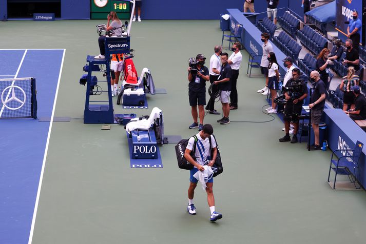 Djokovic yfirgefur völlinn eftir að hafa verið dæmdur úr leik.