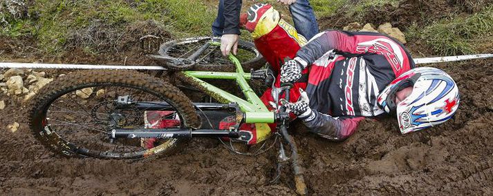 Það getur verið sárt að fara út fyrir brautina og líklegt að sú svaðilför endi einmitt í forinni. Þessi hjólreiðakappi lá vankaður eftir volkið.