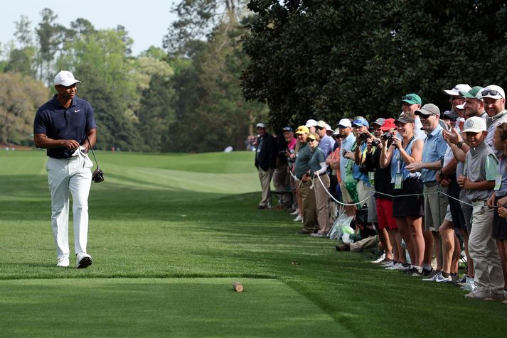 Tiger Woods gengur frá áhugasömum áhorfendum á Augusta National golfvellinum í gær.