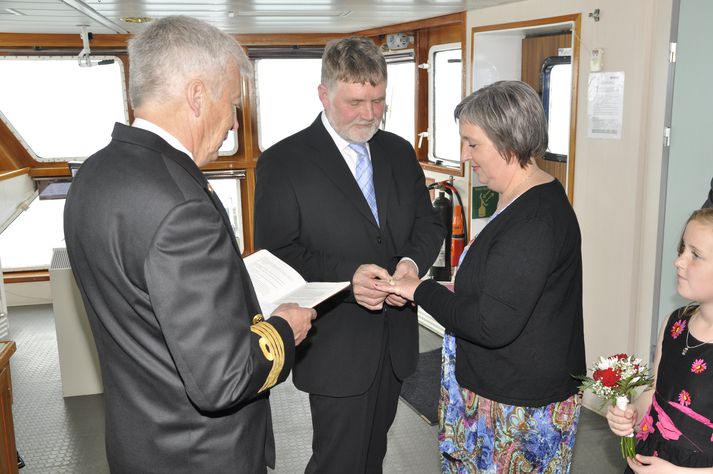 Sigmar Jónsson dregur hér hring á fingur eiginkonu sinnar Hólmfríðar Kristínar Helgadóttur, en þau voru gefin saman í brú Herjólfs af Steinari Magnússyni, skipstjóra.