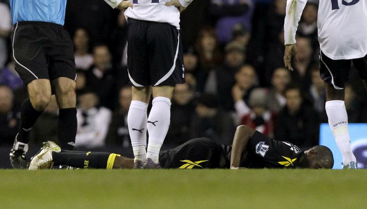 Fabrice Muamba liggur hér í grasinu.