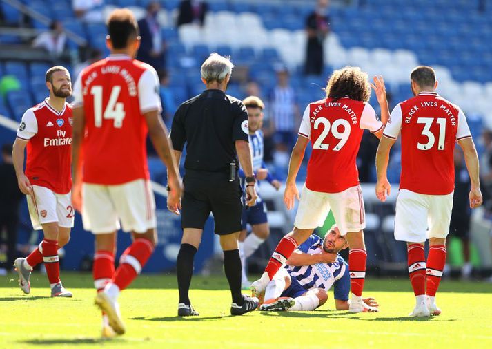 Neal Maupay fékk létt högg frá Guendouzi undir lok leiks og lá eftir.