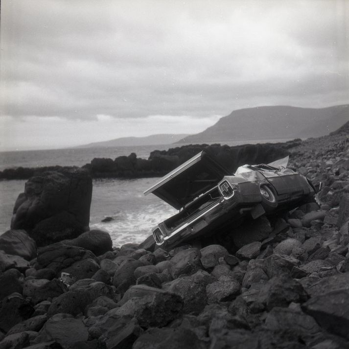 Ljósmynd af bílnum í fjörunni undir Óshlíðarvegi.