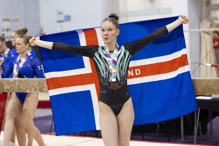 Rakel Sara Pétursdóttir með íslenska fánann og verðlaunapening um hálsinn.