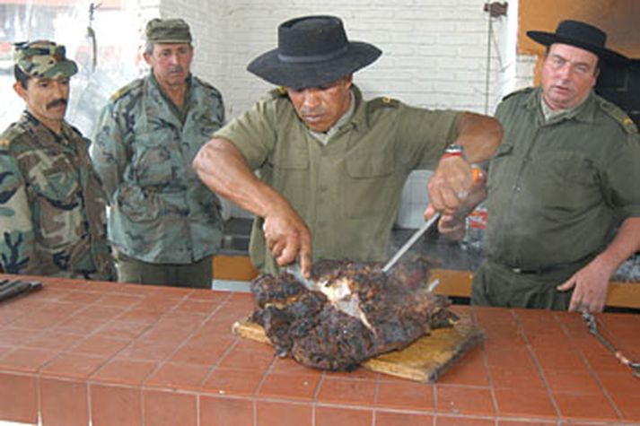 Kokkur í her Uruguay sneiðir steik ofan í hungraða vinnufélagana.