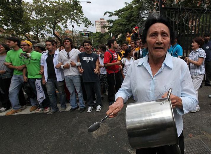 Kona ber á pott í fararbroddi mótmæla í Caracas. Líklega þarf ekki að velkjast í vafa um hvaðan fyrirmyndin að þessu formi mótmæla er fengin.fréttablaðið/AÆ