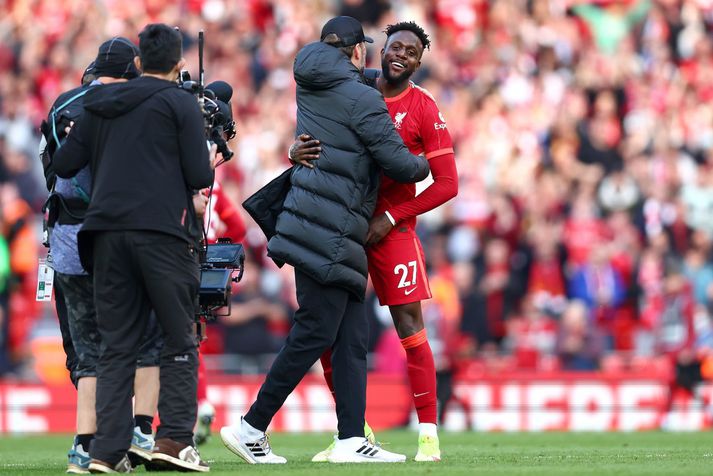 Jürgen Klopp faðmar Divock Origi í leikslok eftir sigur Liverpool á Everton í gær.