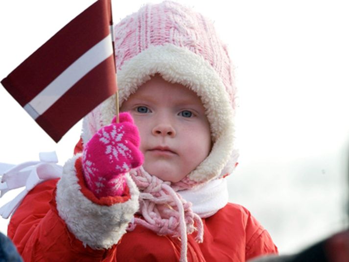 Ung stúlka með lettneska fánann. Hún mun þó eflaust ekki kjósa í dag.