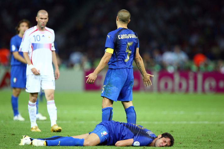 Marco Materazzi liggur í grasinu eftir að Zinedine Zidane skallaði hann.