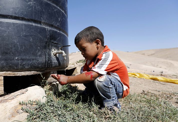 Palestínskur drengur fær sér vatn.