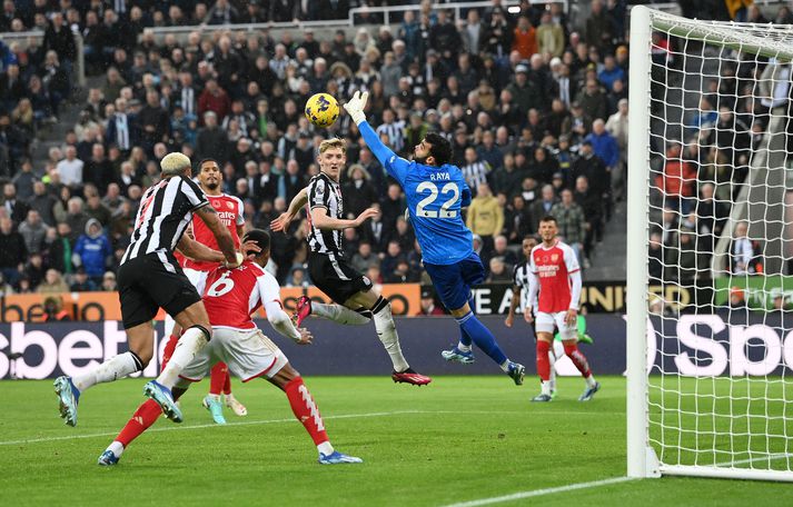 Joelinton gerir sig tilbúinn til að skalla boltann á Anthony Gordon.