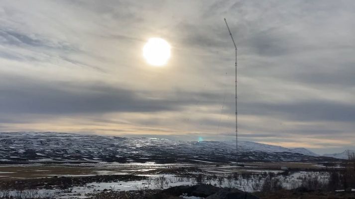 Efsti hluti langbylgjumastursins á Eiðum hrinur eftir að klippt var á stálvíra. Skjáskot á myndbandi.