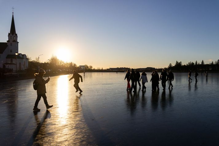 Fólk við leik á Reykjavíkurtjörn. 