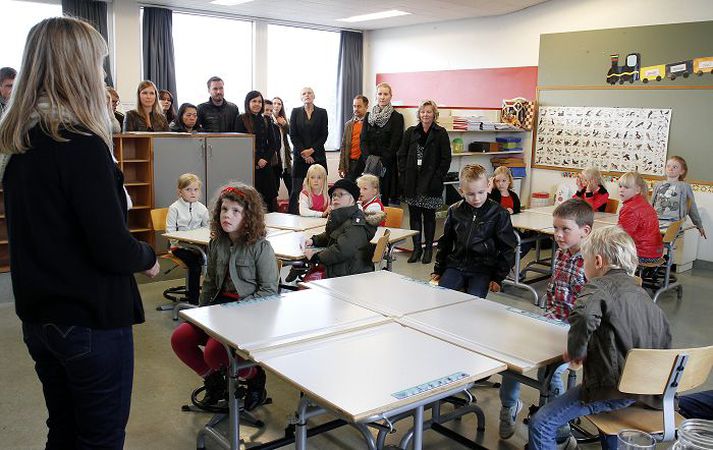 Skólahald hófst víðast hvar í grunnskólum í gær. Hér hlýða nemendur í Hlíðaskóla, ásamt foreldrum, á umsjónarkennara.