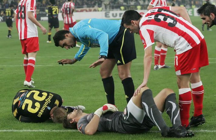Eiður og markvörður Olympiakos eftir áreksturinn. Eiður var borinn af velli.