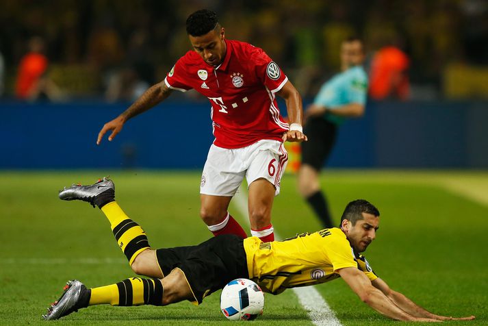 Thiago, miðjumaður Bayern, leikur hér á varnarmann Dortmund.