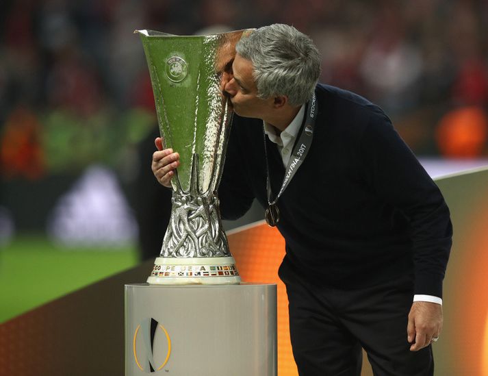 Jose Mourinho brá á leik með bikarinn í leikslok.