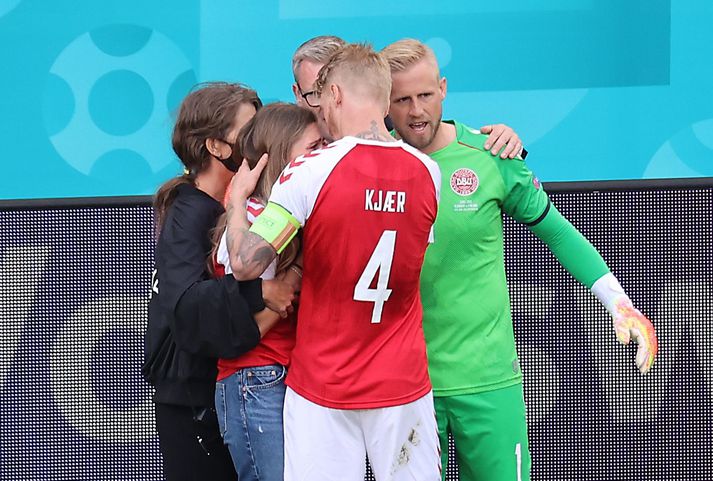 Simon Kjaer [miðja] og Kasper Schmeichel [markvörður Dana] ræða við  Sabrinu Kvist Jensen [kærustu Eriksen] eftir atvikið í dag.