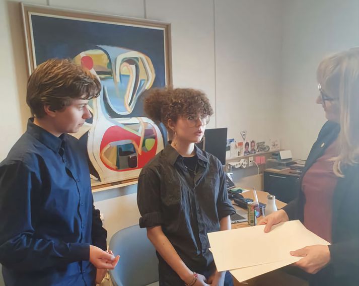 Ingibjörg Hrafnsdóttir og Embla Hlökk Jóhannesdóttir afhenda rektor undirskriftalistana.