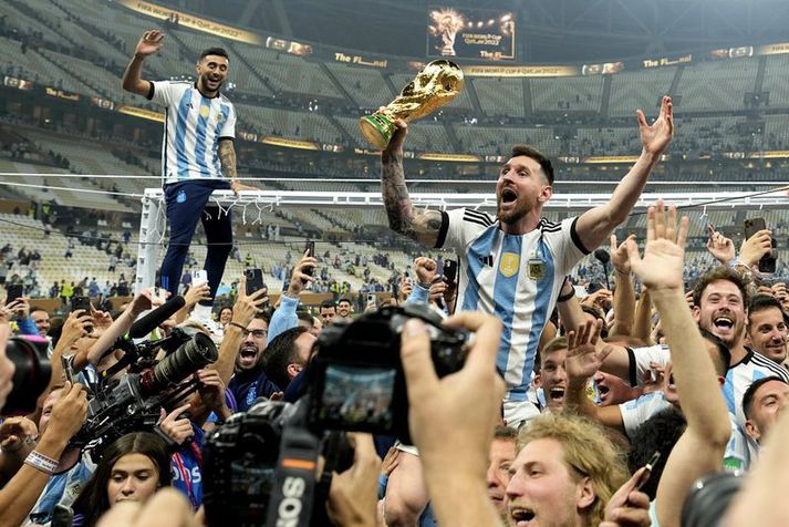 Argentina's Lionel Messi celebrates with the trophy in front of the fans after winning the World Cup final soccer match between Argentina and France at the Lusail Stadium in Lusail, Qatar, Sunday, Dec. 18, 2022. Argentina won 4-2 in a penalty shootout after the match ended tied 3-3. (AP Photo/Martin Meissner)