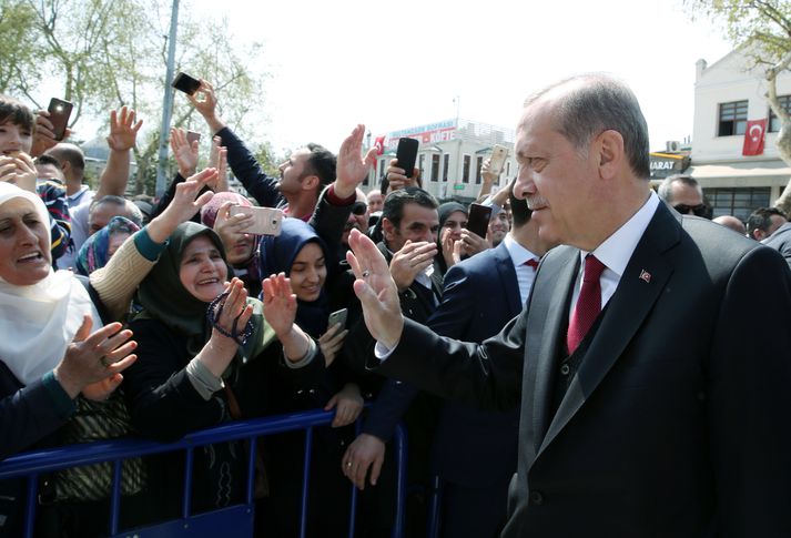 Recep Tayyip Erdogan heilsar fólki eftir að hafa beðið við Eyup Sultan moskuna í Istanbul í gær. Hann fær aukin völd samkvæmt niðurstöðum þjóðaratkvæðagreiðslunnar um helgina.