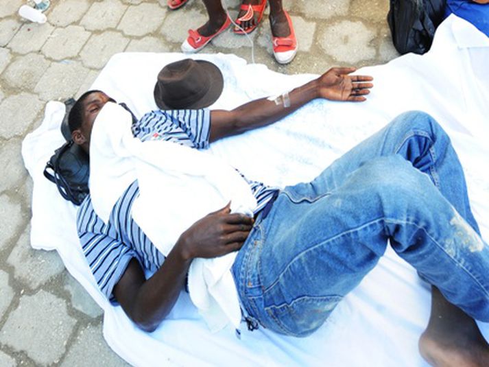 Íbúi í Port au Prince bíður eftir læknisaðstoð. Mynd/ afp.