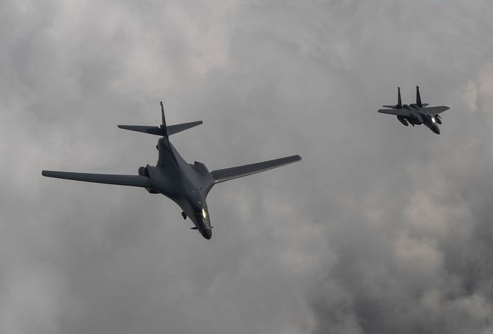 B1-B sprengjuþota og F-15 orrustuþota á flugi yfir Kóreu.
