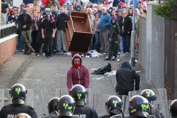 Hér sést mótmælandi henda skáp í lögreglumenn í norðanverðri Belfast í gær.