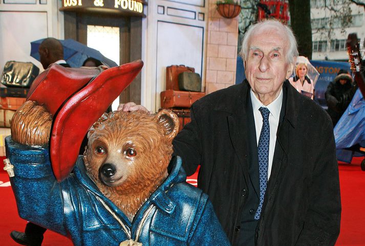 Michael Bond með styttu af Paddington litla.