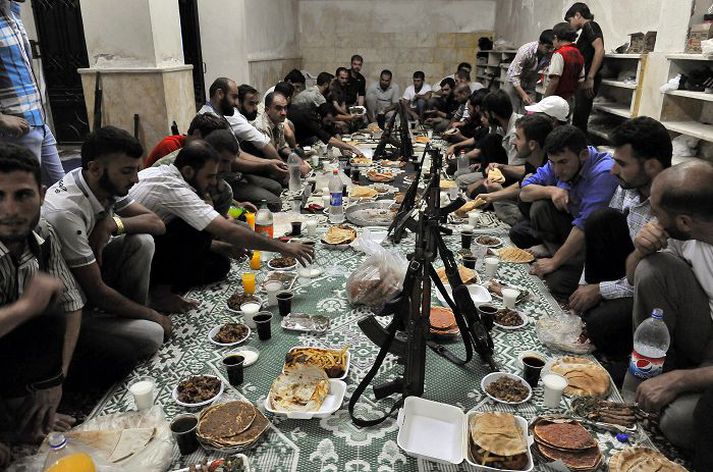 Hópur uppreisnarmanna sestur að snæðingi eftir sólarlag í föstumánuðinum ramadan, sem er nýhafinn.