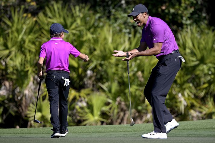 Tiger Woods fagnar hér stráknum sínum eftir að Charlie tryggði feðgunum örn á þriðju holu.