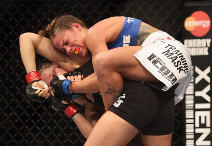 Liz Carmouche á bakinu á Ronda Rousey