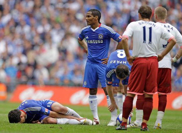 Michael Ballack liggur sárþjáður í vellinum.