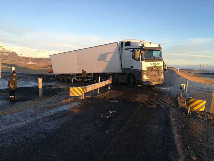 Bifreiðin rann til í mikilli hálku og skorðaðist við ristahlið á veginum.