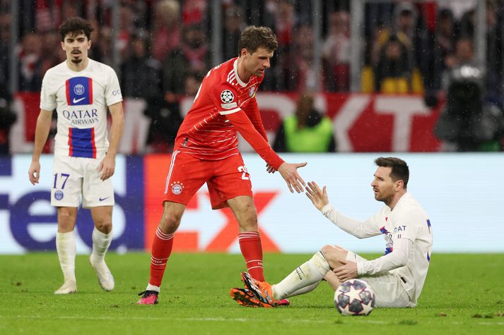 Thomas Muller hjálpar Lionel Messi á fætur í leiknum í kvöld.