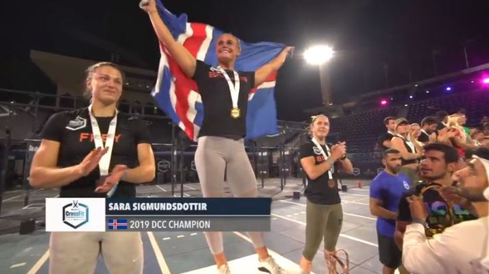 Sara með íslenska fánann á verðlaunapalli.