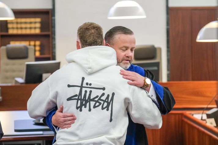 Sævar Hilmarsson faðmar verjanda sinn, Stefán Karl Kristjánsson, sem  tókst á við sækjanda málsins í upphafi þinghalds, með þeim afleiðingum að aðalmeðferð málsins var frestað.