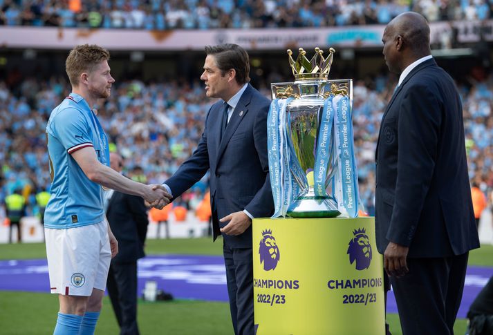 Richard Masters, framkvæmdastjóri ensku úrvalsdeildarinnar, tekur í höndina á leikmanni Manchester City, Kevin De Bruyne, eftir að liðið hafði tryggt sér Englandsmeistaratitilinn á síðasta tímabili