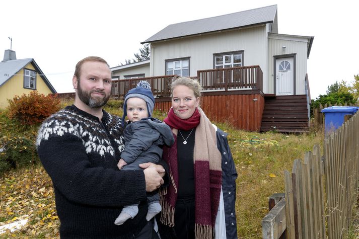 Hjónin Ingvar Ari Arason og Anna Gyða Pétursdóttir með yngsta barn sitt við húsið sem reyndist martröð sem ekki sér fyrir endann á.