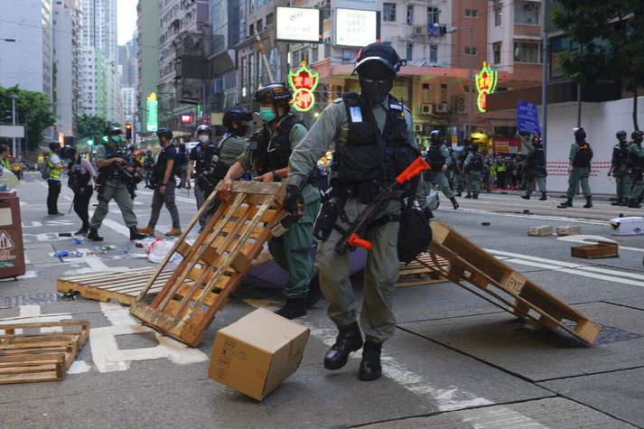 Lögregla fjarlægir vegatálma sem mótmælendur höfðu reist í Hong Kong.