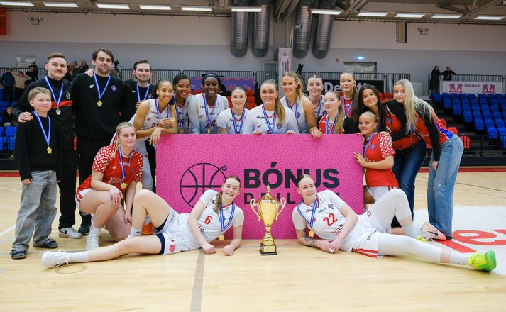 Sólrún Inga #22 liggur afslöppuð með bikarinn sér við hlið. 