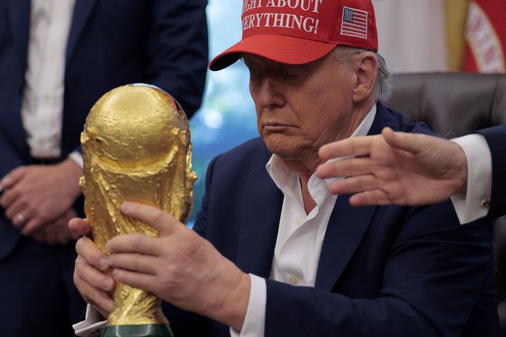 Donald Trump sést hér handleika heimsbikarinn í Hvíta húsinu. Hann mun afhenda hann á sunnudagskvöldið.