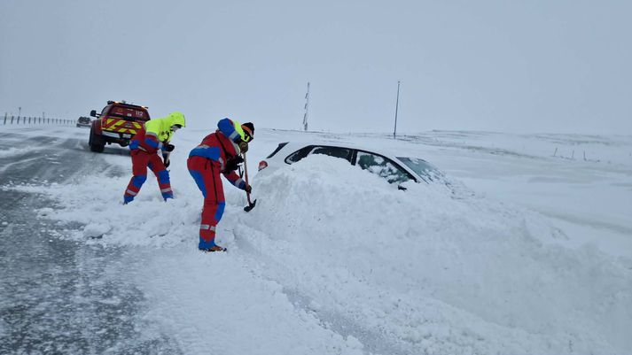 Hjálparsveit Skáta Hveragerði mokar upp bíl í Kömbunum.