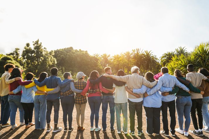Group of multigenerational people hugging each others - Support, multiracial and diversity concept - Main focus on senior man with white hairs Group of multigenerational people hugging each others - Support, multiracial and diversity concept - Main focus on senior man with white hairs