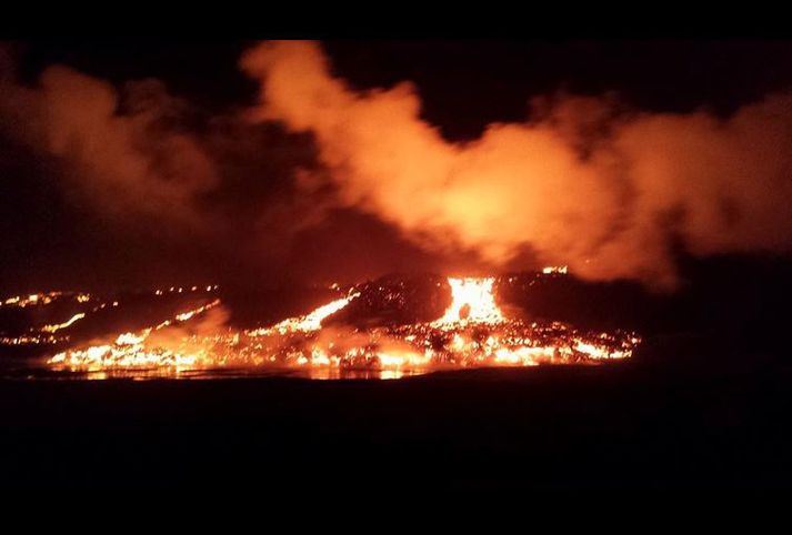 Red-orange lava flow cascading down the edge of the new Holuhraun lava field.