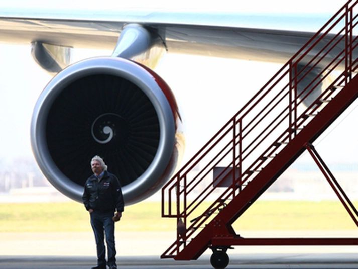 Richard Branson stendur fyrir framan eina vél sína á  Heathrow flugvelli.