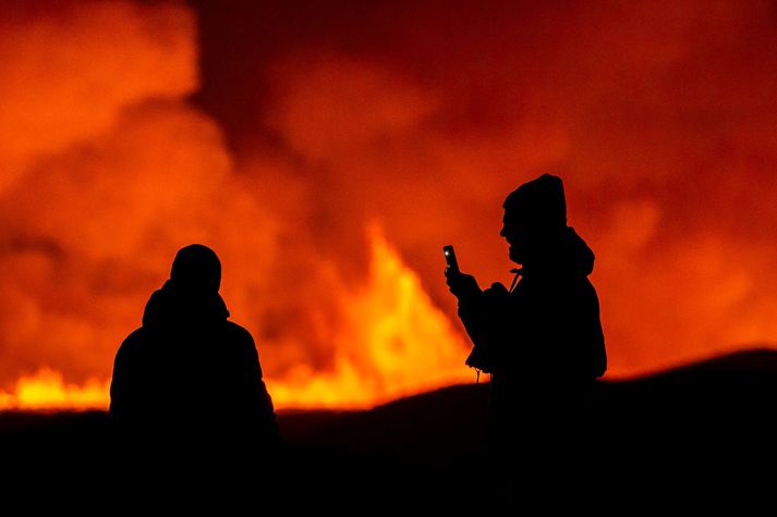 Ferðamenn virða fyrir sér eldtungurnar.
