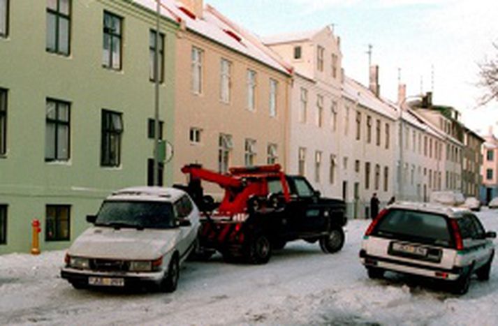 Hvíti Saabinn dreginn af Ásvallagötunni þangað sem ræningjarnir flúðu eftir ránið.