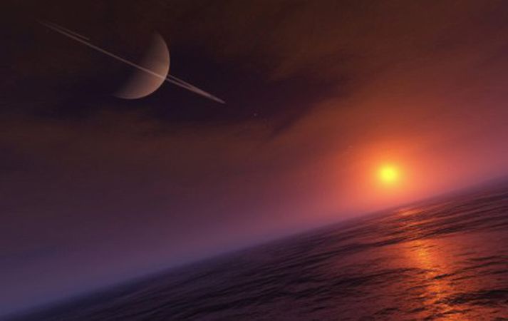 Tölvuteikning af yfirborði Títan. Saturn svífur fyrir ofan.